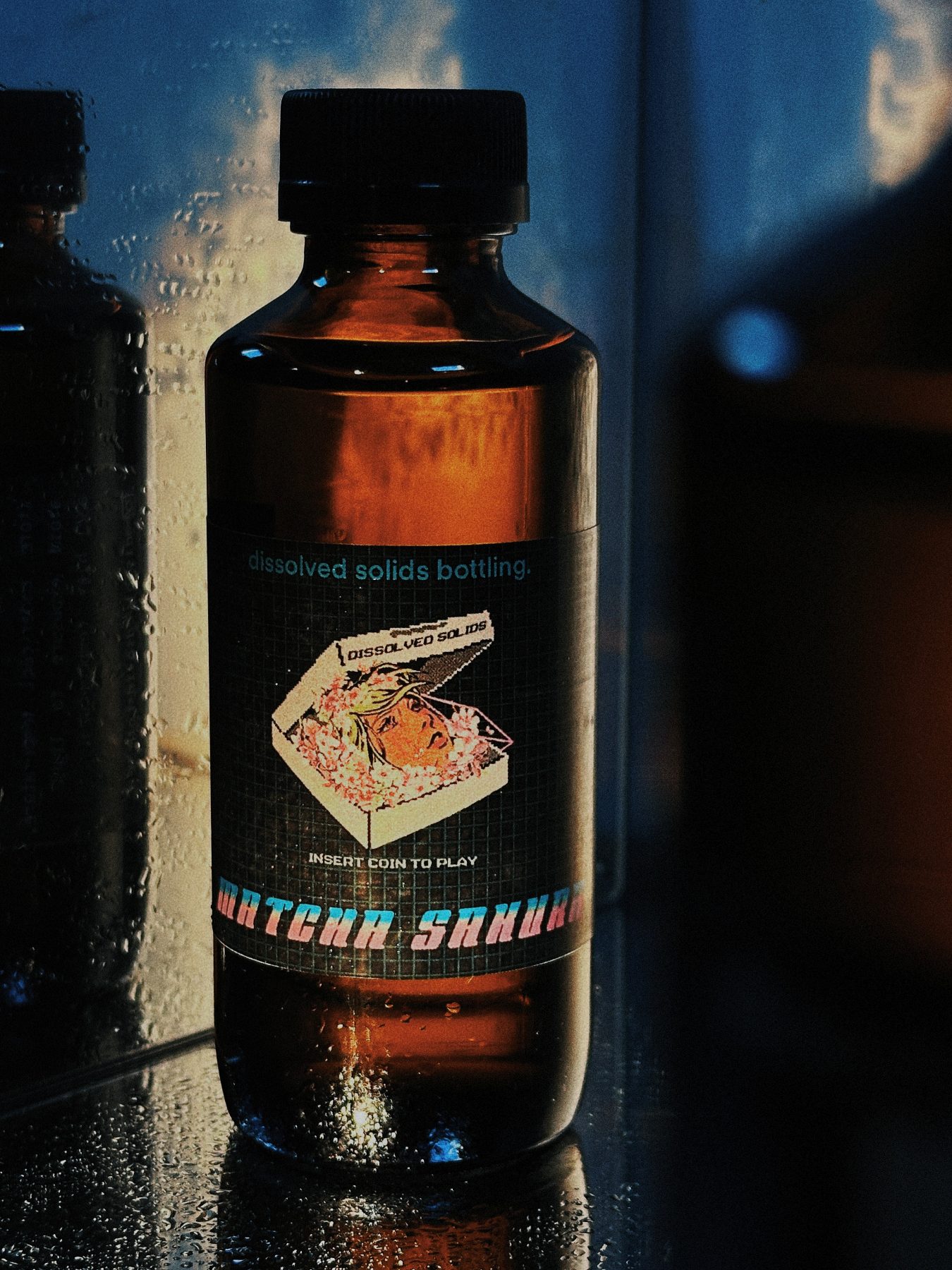 Dissolved Solids Matcha Sakura bottled cocktail with custom pixel-art label in soft evening light