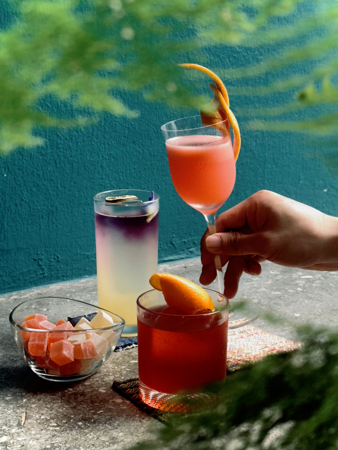 Three customised cocktails outdoors with turkish-delight cubes in pastel colours at Dissolved Solids