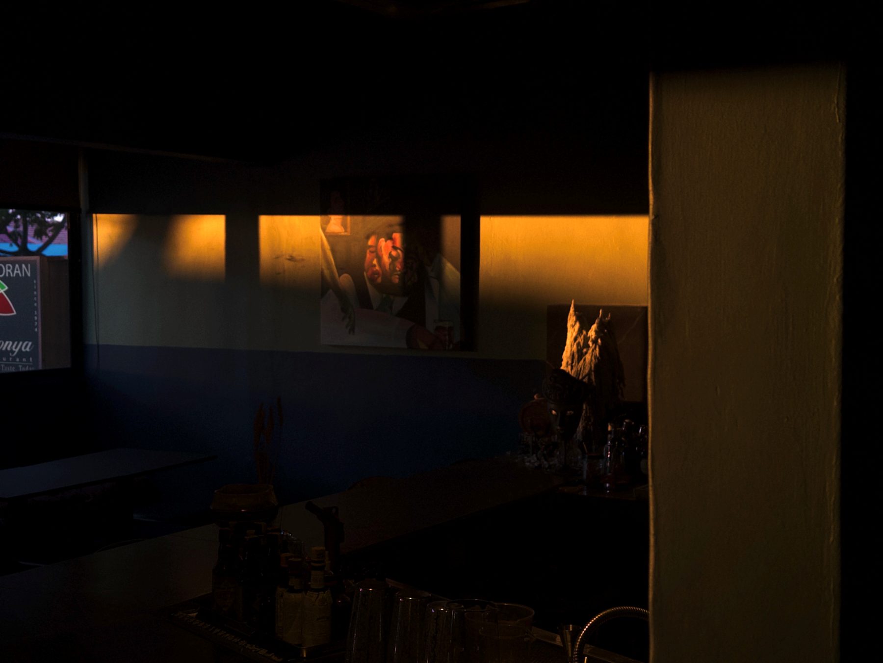 Moody interior of Soluble Solids SS2 with framed portrait and warm lamp light