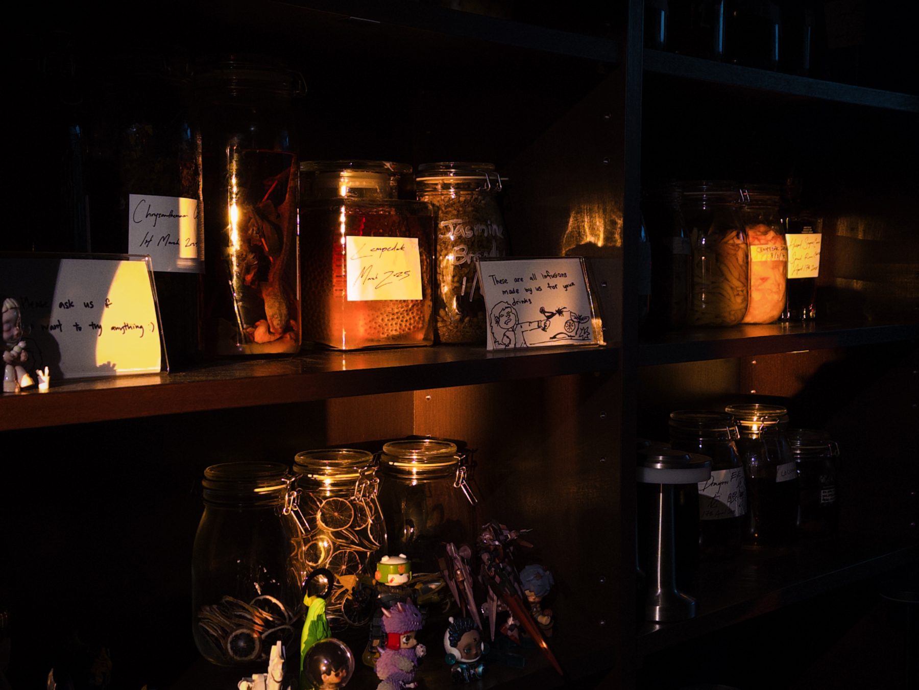 Soluble Solids infusion shelf with handwritten labels and a small note: 'these are all infusions made by us for your drinks'
