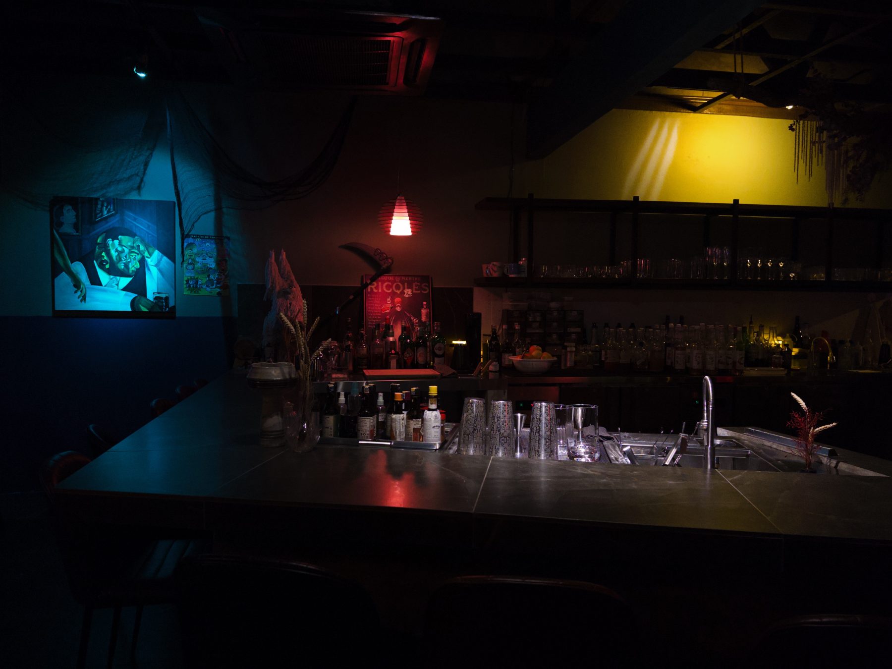 Soluble Solids interior with painted wall art, red pendant lamp and full back bar in SS2