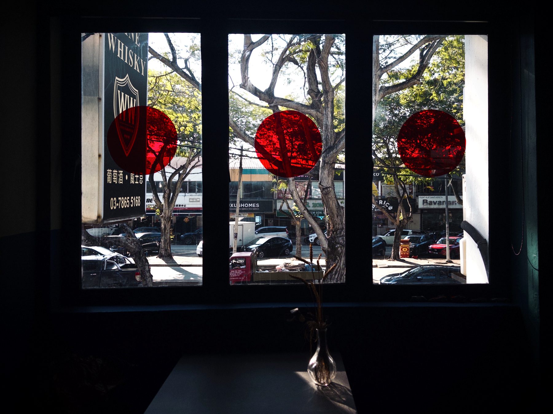 Window at Soluble Solids with red glass decals overlooking SS2 Petaling Jaya street